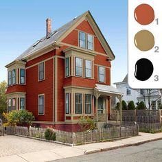 a large red house with lots of windows next to a fence and street sign in front of it