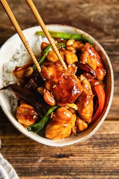 a bowl filled with chicken and vegetables on top of rice