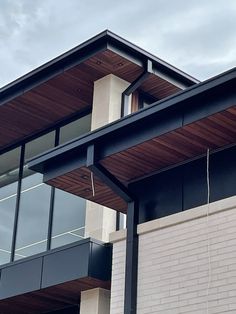 a clock on the side of a building with glass and wood trim around it's sides