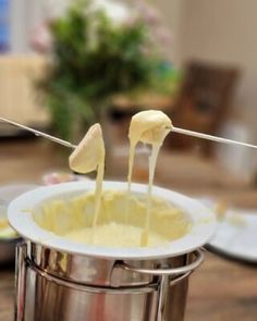 some food is being made in a saucepan on a table with utensils