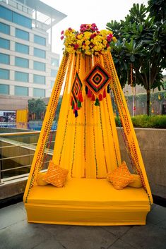 a yellow canopy decorated with flowers and beads