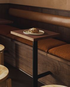 a table with a plate of food on top of it next to two stools