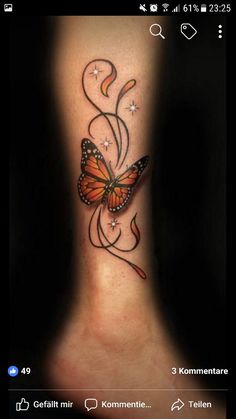 a small butterfly tattoo on the side of a woman's leg with stars and swirls