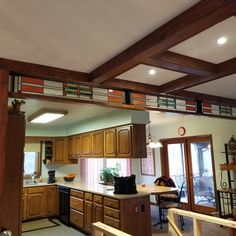 an open kitchen with wooden cabinets and stained glass window above the countertop, is shown from across the room