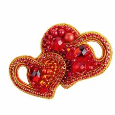 two red heart shaped brooches with beads