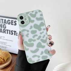 a woman is holding up her phone case with an animal print on it, while she holds