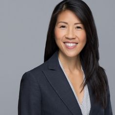 a woman in a business suit smiling at the camera