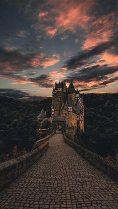 an image of a castle that is in the sky with clouds above it and cobblestone walkway leading up to it