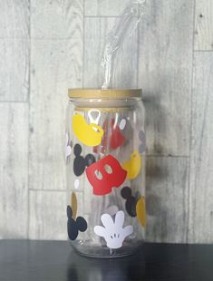 a glass jar with mickey mouse decals on it