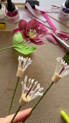 someone is making flowers out of paper and glue