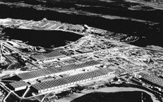 an aerial view of a large industrial area in the middle of the day, with buildings and water surrounding it