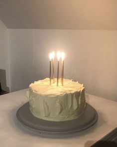 a white cake with four lit candles on it