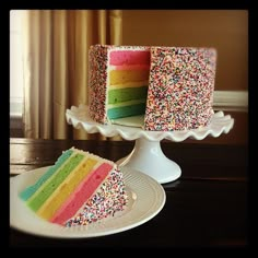 a slice of cake with sprinkles is on a plate next to it