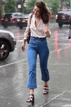 a woman walking in the rain with an umbrella