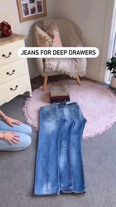 jeans for deep drawers are sitting on the floor next to a woman's legs