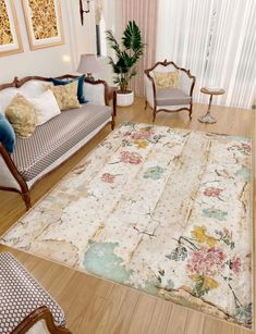 a living room filled with furniture and a rug on top of a hard wood floor