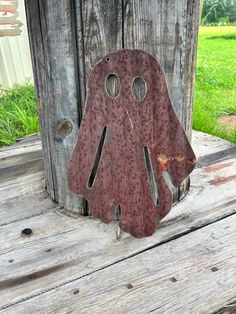 an old metal object sitting on top of a wooden table in front of a fence