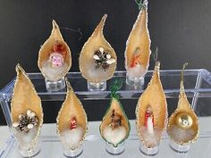 twelve christmas ornaments in glass vases sitting on a table