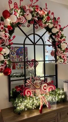 a christmas wreath with candy canes and candies hanging on the front of it