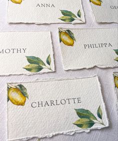 A photograph of 3 place cards made from textured 100% recycled cotton paper with a deckle edge. The place cards have a watercolour lemon printed onto the top left hand corner and leaves on the bottom right hand corner. The name Charlotte can be read in capital letters in a mid-grey colour in a serif font. Lemon And Sage Wedding, Italian Wedding Place Cards, Italian Wedding Name Cards, Lemon Dinner Party, Wedding Decoration Lemon, Handmade Decoration Ideas, Lemon Theme Wedding, Lemon Wedding Decor, Lemon Place Setting