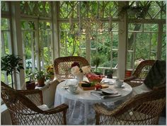 there is a table with plates and cups on it in front of the glass windows