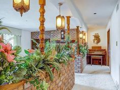 the hallway is lined with potted plants and chandeliers