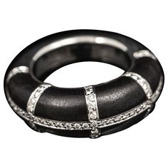 Chaumet "Anneau” diamond and ebony cocktail ring in 18kt white gold, French, vintage from the late 20th century. Of a bombe design, the top part of this ring is composed by ebony plaques divided in eight sections by lines of round brilliant-cut diamonds grain-set in white gold, leading to a thick D- shape shank in white gold. Diamonds: 77 stones; round brilliant-cut; estimated 0.40 carats in total. Signed "CHAUMET PARIS”; serial number "661708-750”; French hallmark "eagle’s head” for 18kt gold; Bee My Love Chaumet Rings, Chaumet Jewelry, Chaumet Josephine Earrings, Chaumet Hortensia, Chaumet High Jewelry, French Modern, Van Cleef Arpels, Late 20th Century, Ring Vintage