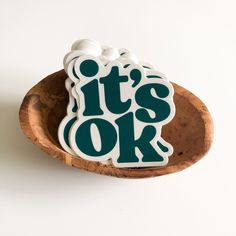 it's ok sticker sitting on top of a wooden spoon in a bowl