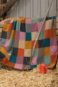 a multicolored blanket sitting on top of hay