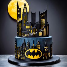 a batman themed birthday cake with the city skyline and bat symbol on it's icing