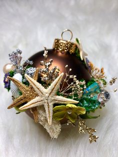 a christmas ornament with starfish, seashells and other decorations on white fur