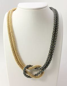 a necklace on a mannequin with two strands of beaded beads in gold and blue