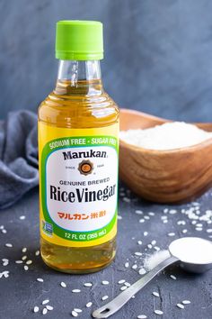 a bottle of rice vinegar next to a spoon