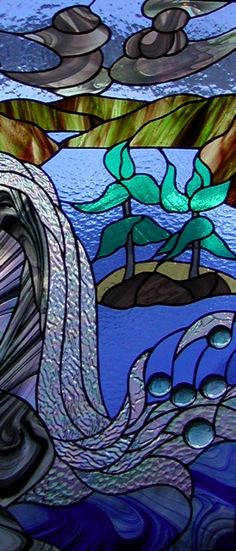 a stained glass window with water and rocks in it's center, as well as an image of the ocean