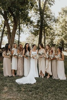 a group of women standing next to each other on top of a grass covered field