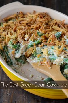 the best green bean casserole recipe is in a yellow dish with a wooden spoon