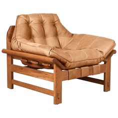 a brown leather chair with wooden frame and footrests on an isolated white background