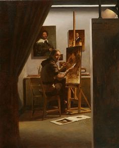 a man sitting in front of an easel painting