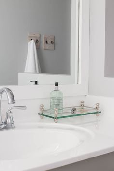 a bathroom sink with a soap dispenser on the counter and a mirror above it