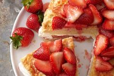 there is a cake with strawberries on the plate and one slice missing from it