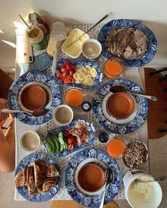 a table filled with different types of food and drinks on top of blue china plates