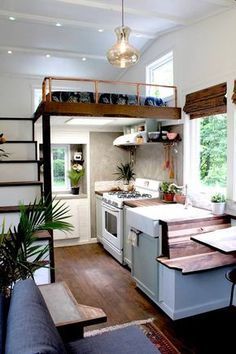 a kitchen with stairs leading up to the loft