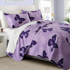 a bed with purple butterflies on it in a bedroom