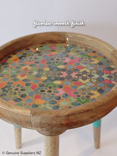 a small wooden table with multicolored tiles on it's top and legs