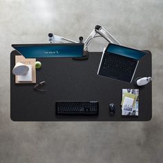 an overhead view of a desk with a laptop, keyboard and other office supplies on it