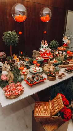 a table filled with lots of food on top of a white table covered in orange and red decorations