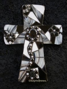 a cross made out of glass on a black surface