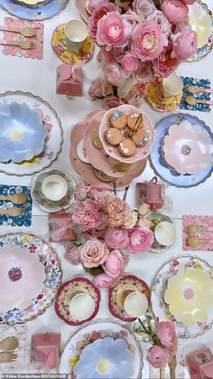 a table topped with lots of plates covered in pink flowers