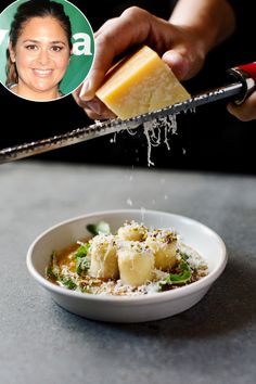 a woman is sprinkling cheese on food in a bowl