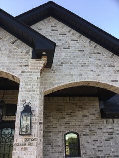 a brick house with arched windows and an iron gate